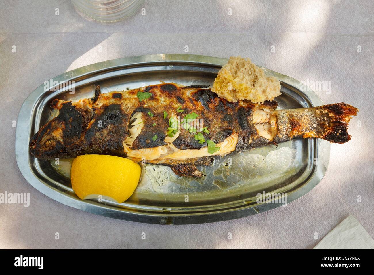 Trota arrosto cucinata e servita nel villaggio di Agios Floros, Kalamata, regione della Messinia, Peloponneso, Grecia, Europa. Foto Stock