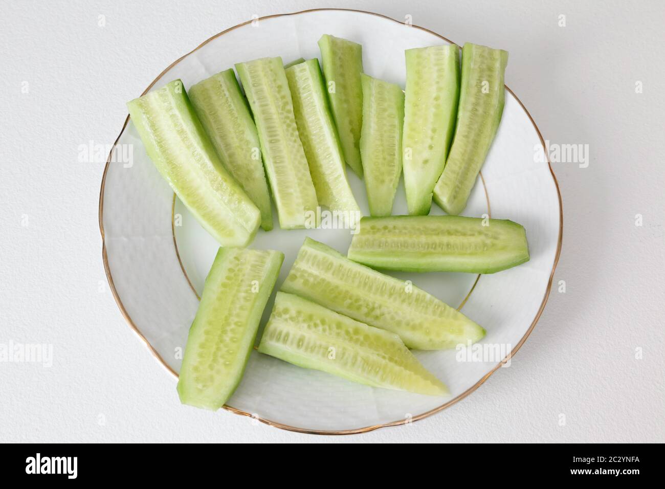 Cetriolo affettato su piatto bianco. Foto Stock