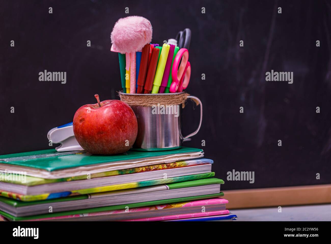 Ritorno a scuola con libri e mela su lavagna. Foto Stock