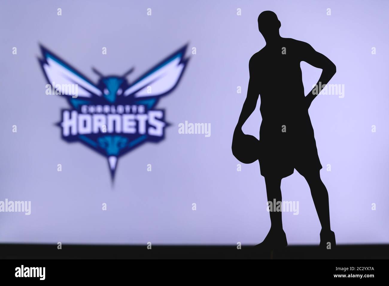 NEW YORK, USA, 18 GIU 2020: Charlotte Hornets logo di club di basket professionale nella lega americana. Silhouette del giocatore di basket in primo piano. SpO Foto Stock