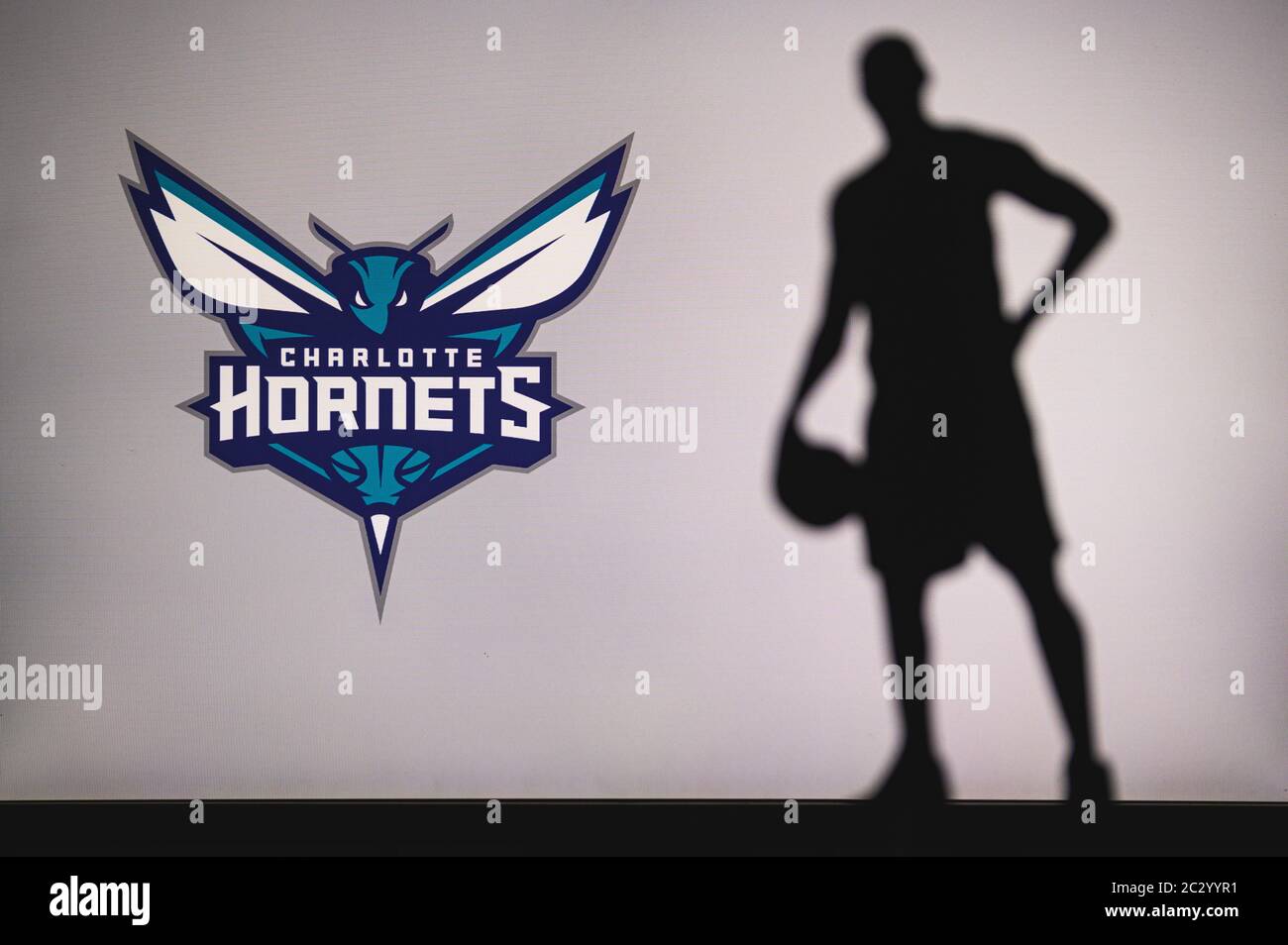 NEW YORK, USA, 18 GIU 2020: Charlotte Hornets logo di club di basket professionale nella lega americana. Silhouette del giocatore di basket in primo piano. SpO Foto Stock