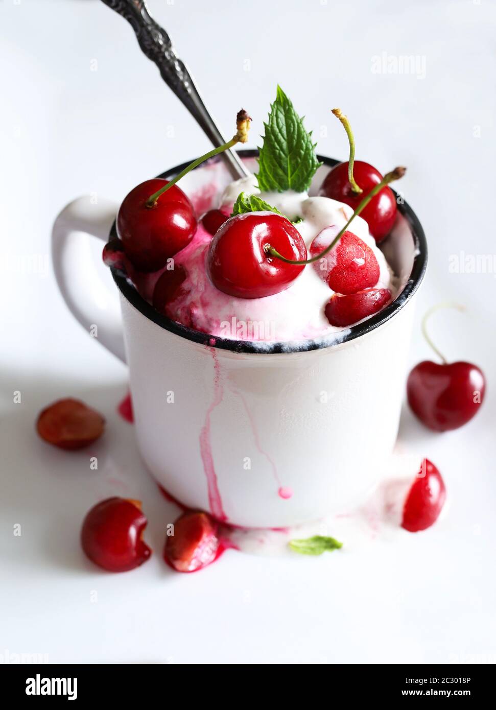 Concetto di cibo dolce. Gelato delizioso con ciliegia in una tazza bianca. Messa a fuoco selettiva. Foto Stock