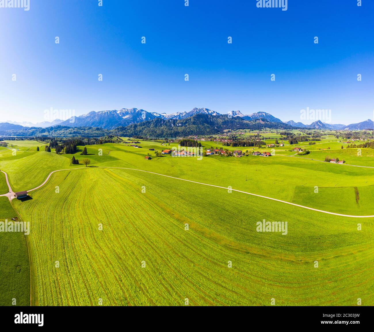 Villaggi in paesaggio culturale di fronte al Tannheimer Berge con Hohe Schlicke, Brentjojch e Aggenstein, drone-immagine, Allgaeu orientale, Allgaeu Foto Stock