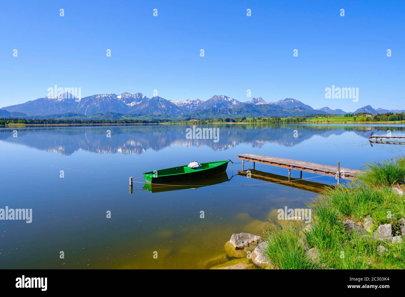 Punt legato al molo, Hopfensee, Tannheimer Berge con Gehrenspitze, Hohe Schlicke, Brentjojich e Breitenberg, Hopfen am See, vicino a Fuessen Foto Stock