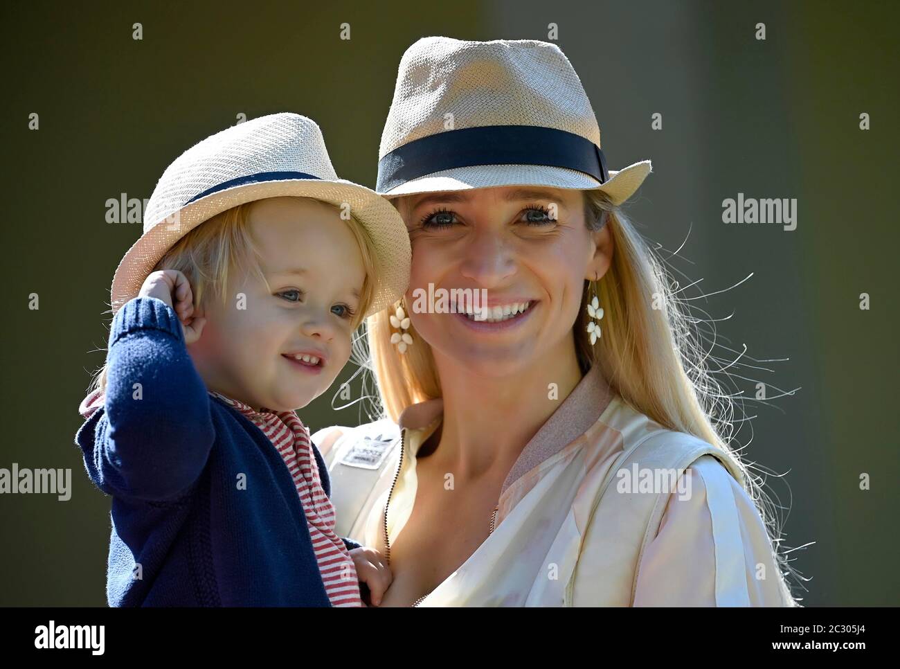 Madre che tiene il figlio, 19 mesi, in braccio, entrambi indossando cappello simile, Stoccarda Baden-Wuerttemberg, Germania Foto Stock