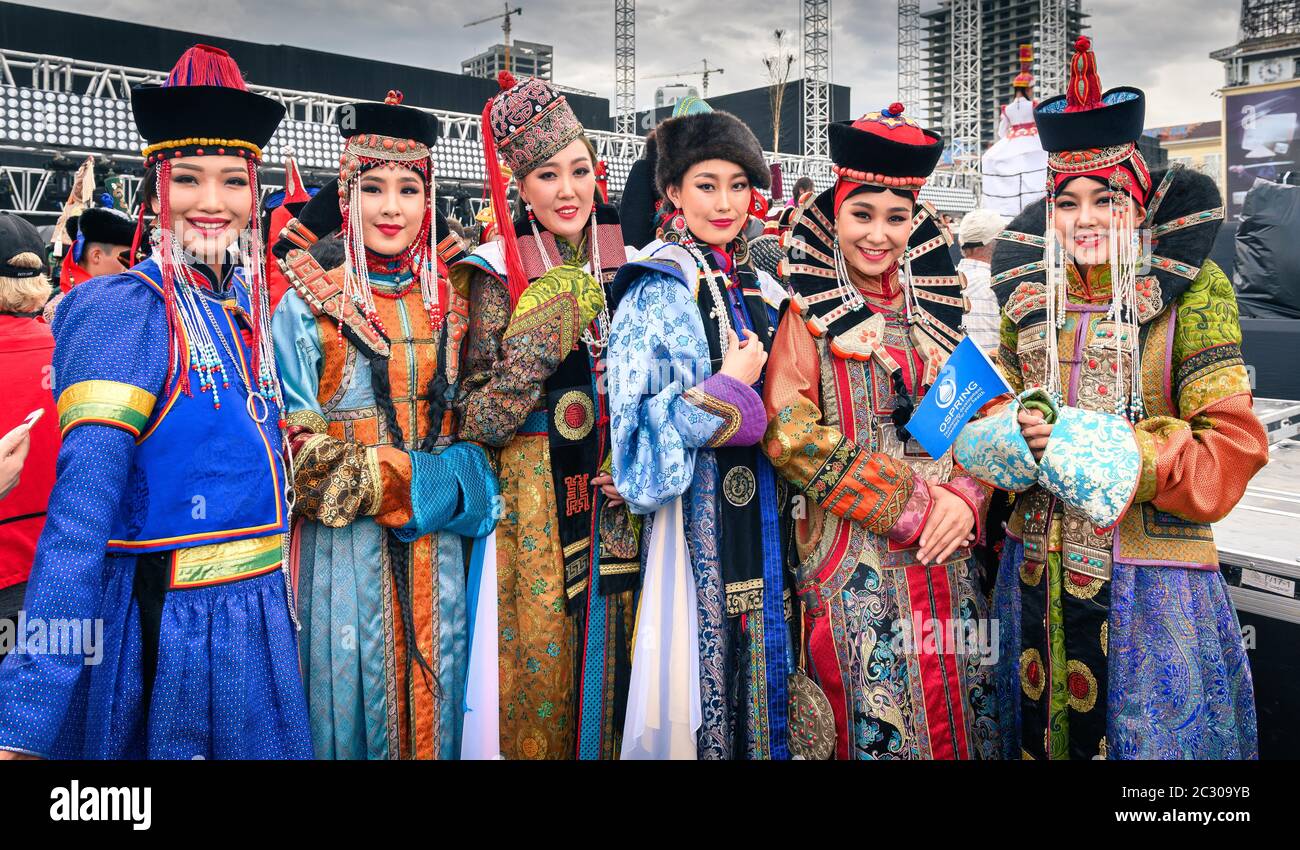 Belle giovani Signore che soggiornano in mongolo costumi tradizionali di diversi gruppi etnici nella piazza centrale, nel DEEL (abito nazionale) Foto Stock