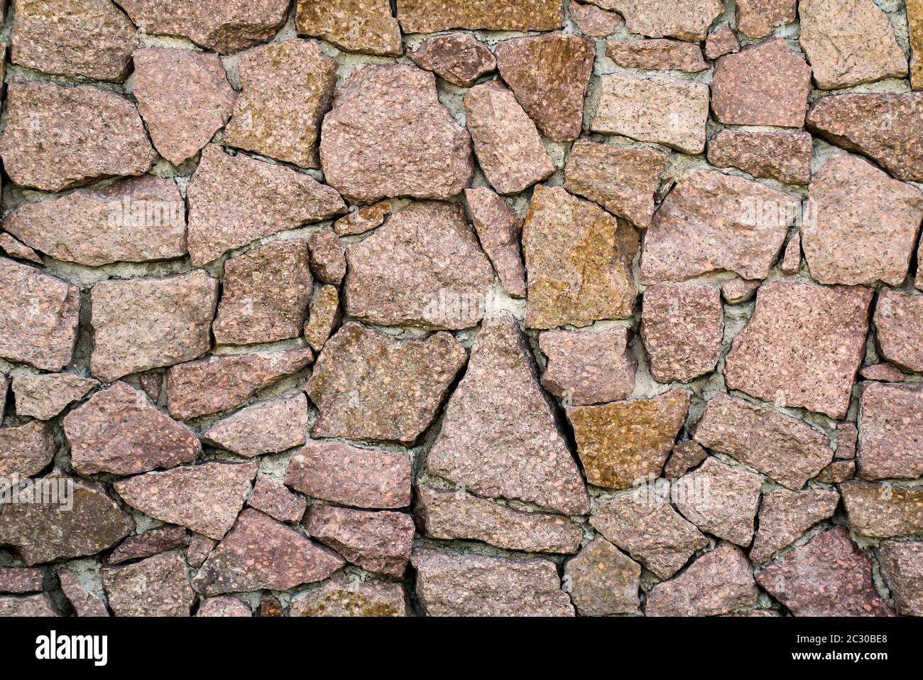 una parete di pietra di pietre di granito, struttura della parete di pietra Foto Stock