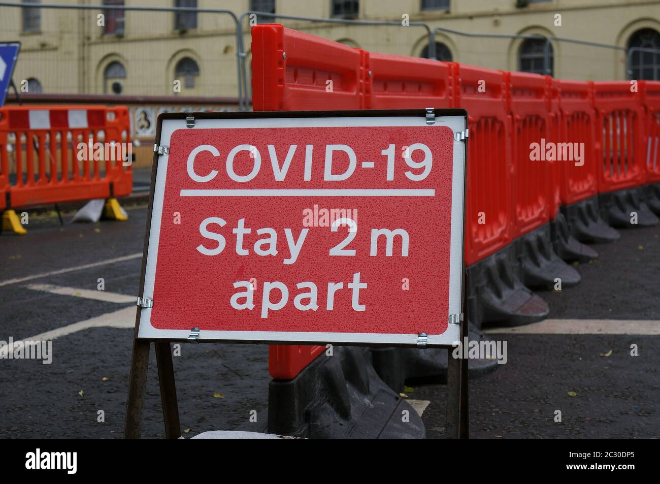 Coronavirus `sa 2 metri di distanza` cartello di avvertimento vicino ai lavori stradali sul ponte della città Foto Stock