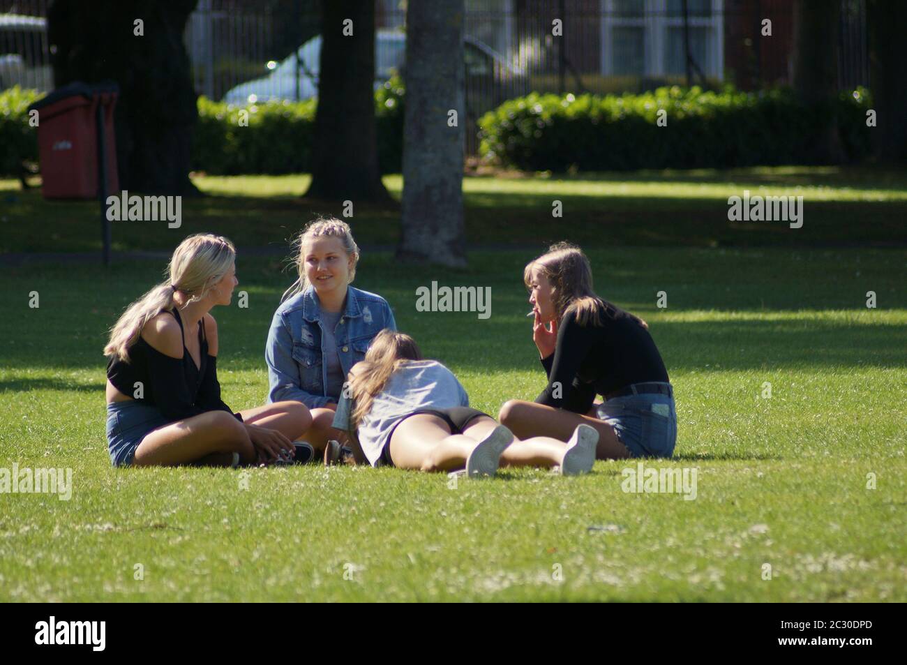Giovani donne attraenti che si siedono insieme nel parco su un giorno di sole Foto Stock