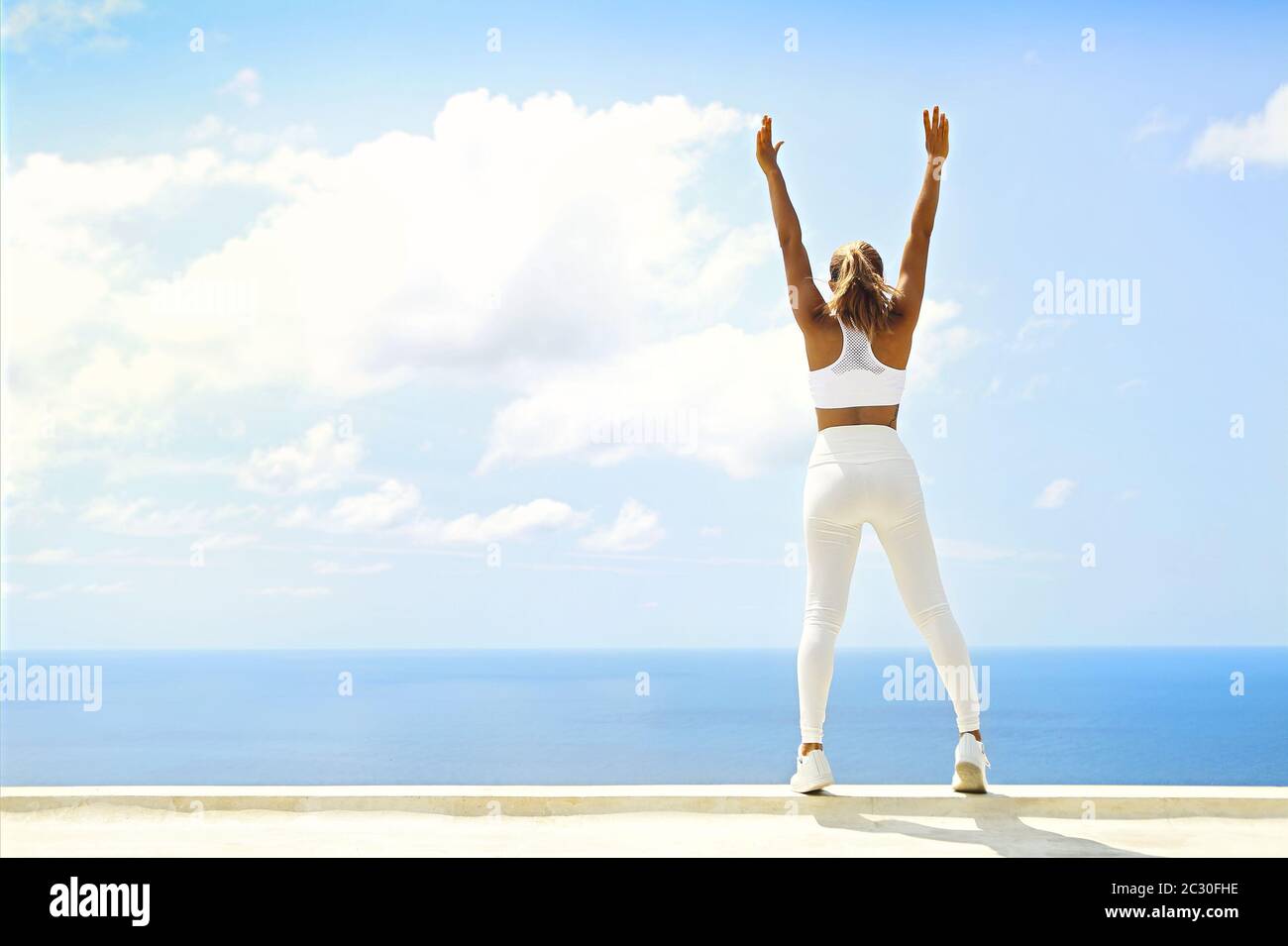 Bella donna che fa esercizi di stretching in spiaggia Foto Stock