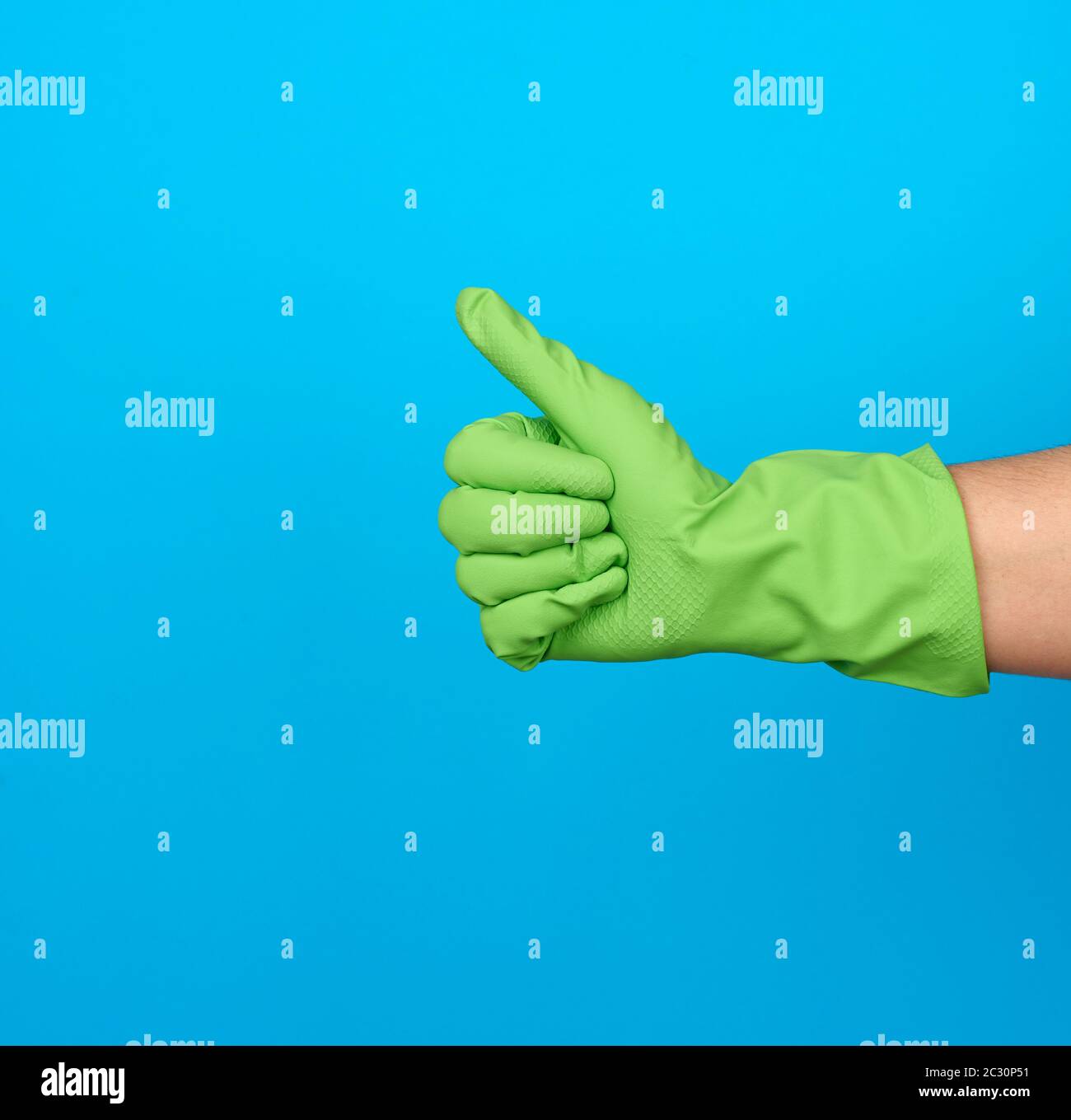 i guanti in gomma di protezione verde mostrano gesti come sfondo blu, emozione positiva, consenso Foto Stock