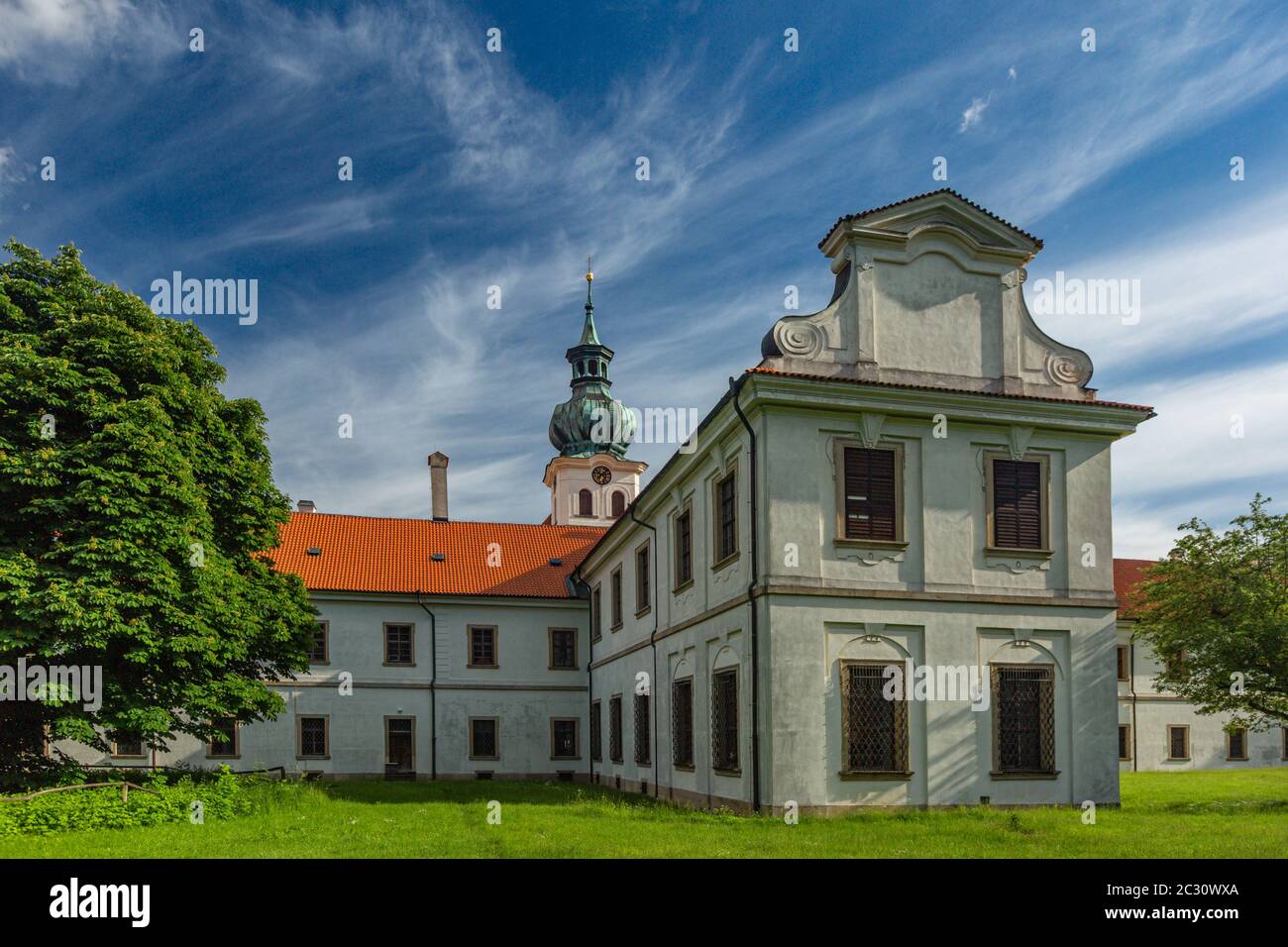 Brevnov, Praga / Repubblica Ceca - Giugno 11 2020: Vista del primo monastero maschile in Boemia in piedi in un parco con alberi verdi in una giornata estiva soleggiata. Foto Stock