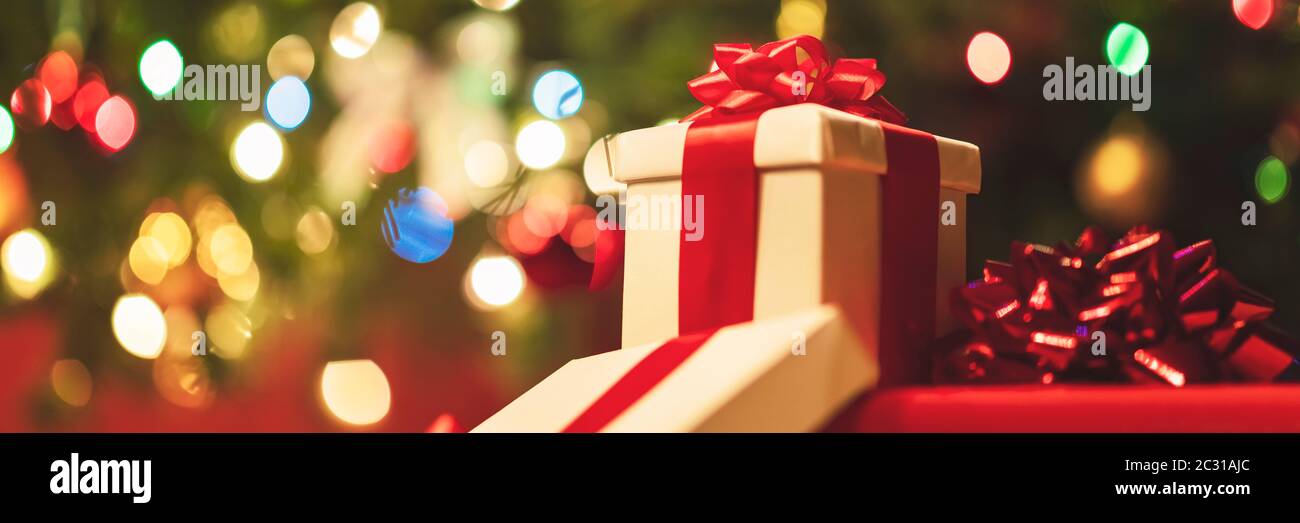 confezioni regalo con nastro e prua su sfondo luci di vacanza Foto Stock