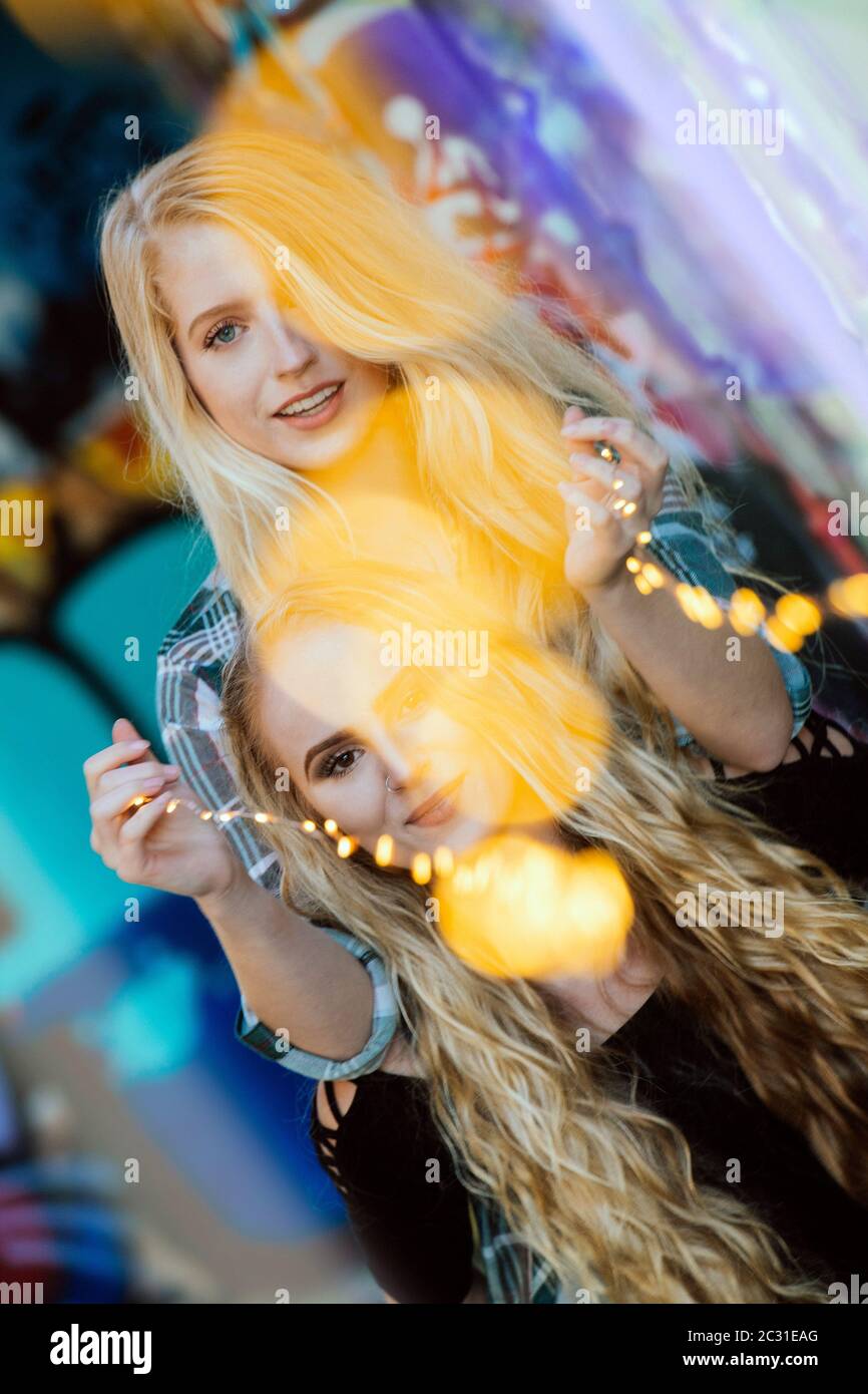 Due modelli con capelli lunghi che giocano con luci a Bainbridge Island, Washington, USA Foto Stock
