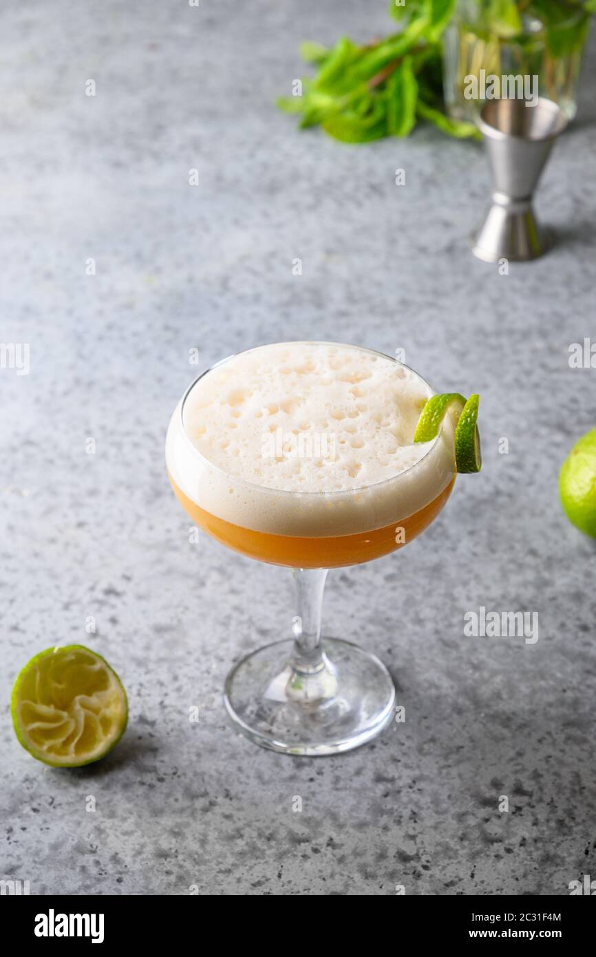 Pisco Sour cocktail di whisky, lime su grigio. Foto Stock