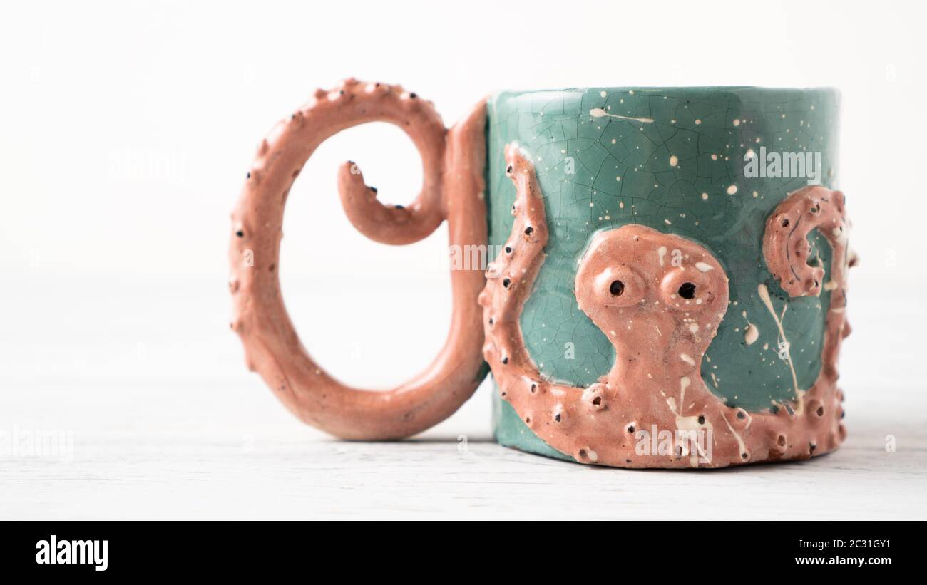 Tazza di Kraken. Tazza di argilla. Tazza originale come regalo. Tazza per bambini. Artigianato del polpo. Tazza personalizzata. Tazza di caffè. Foto Stock