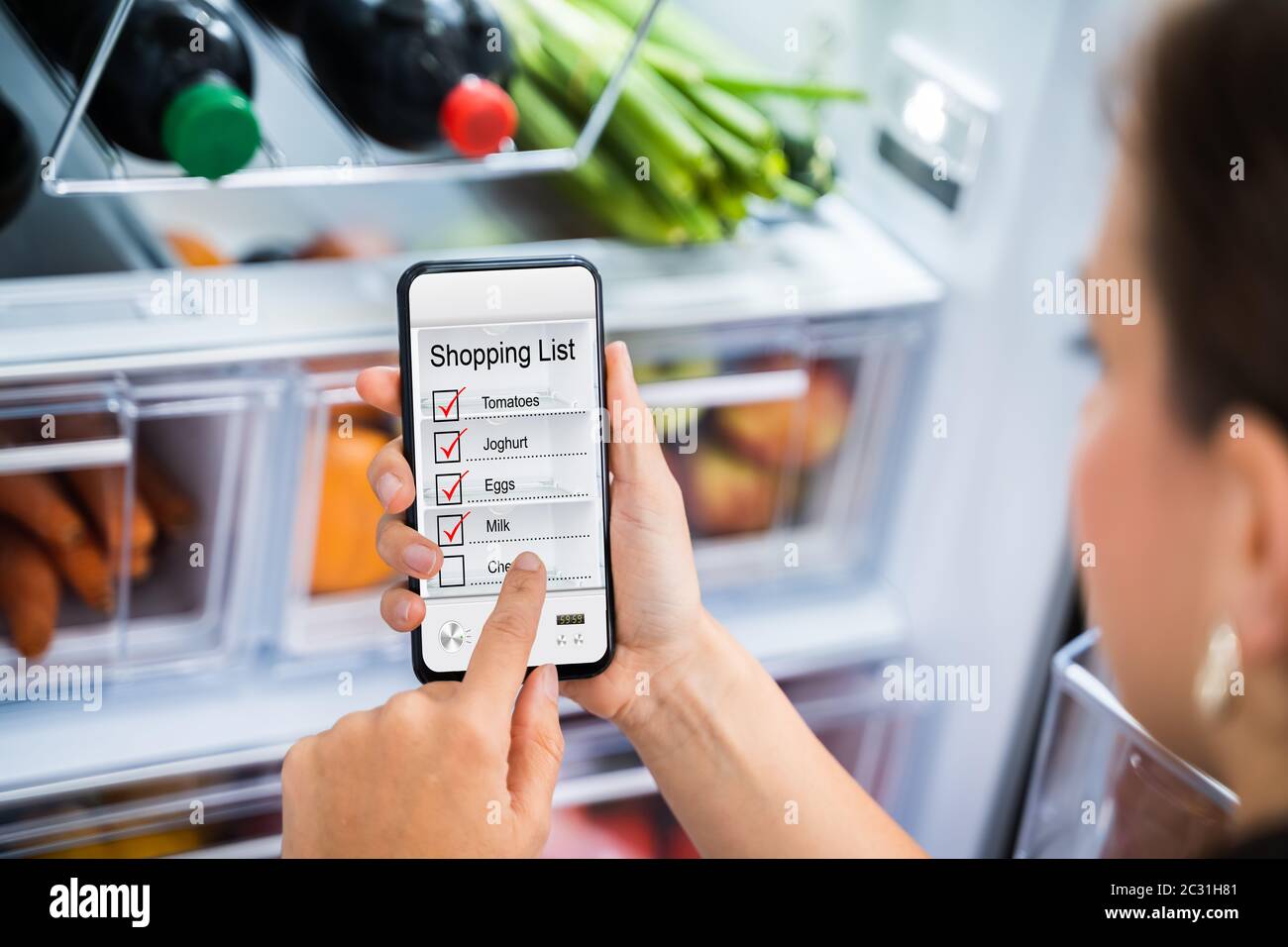 Comoda lista di negozi di alimentari, app per telefono vicino al frigorifero Foto Stock
