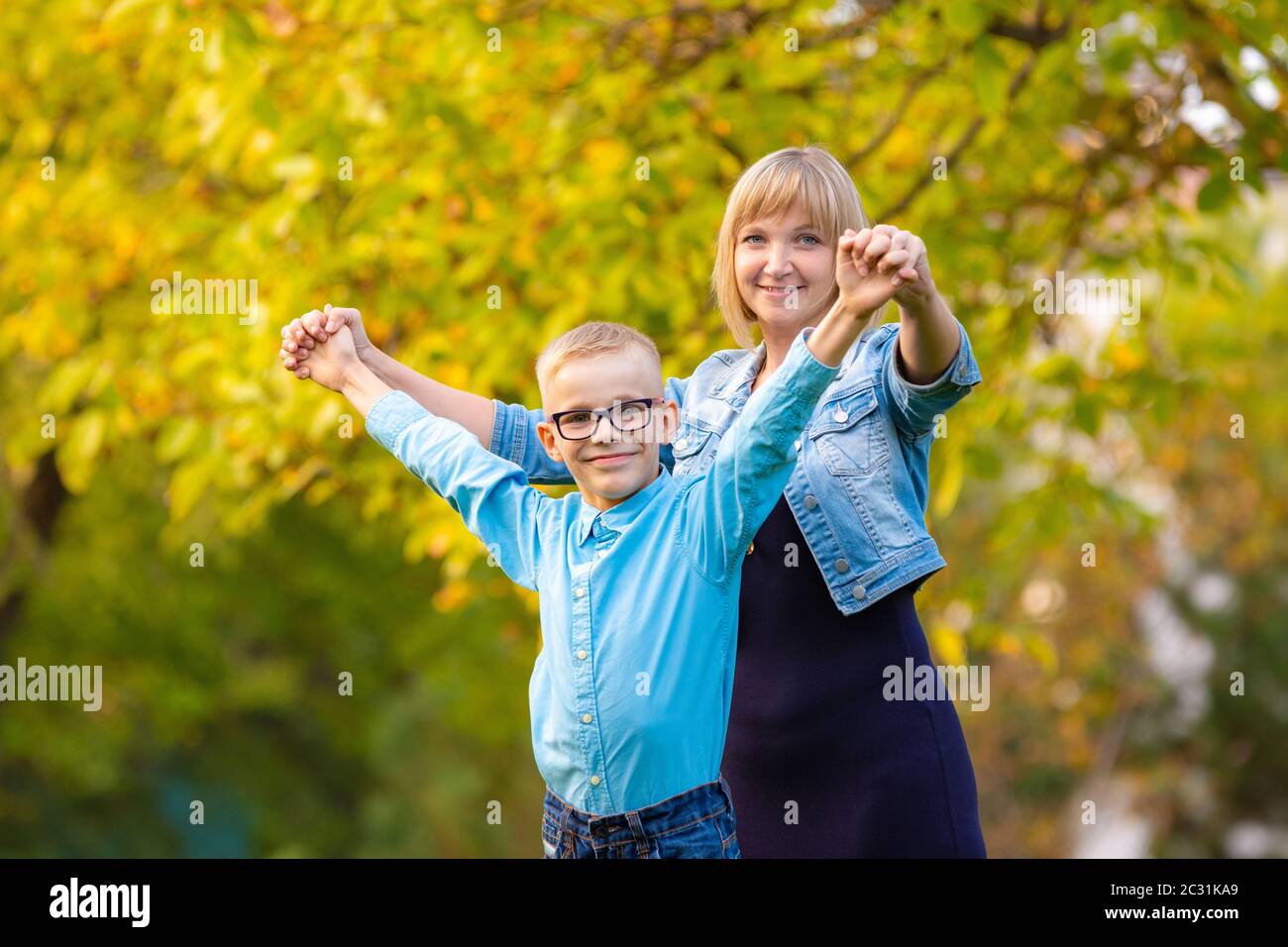 Mamma e figlio di sette anni si divertono nel parco autunnale Foto Stock