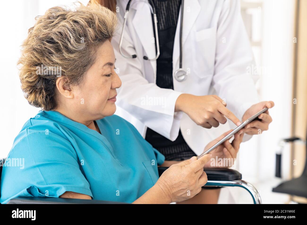 Medico che usa la compressa con il paziente anziano Foto Stock