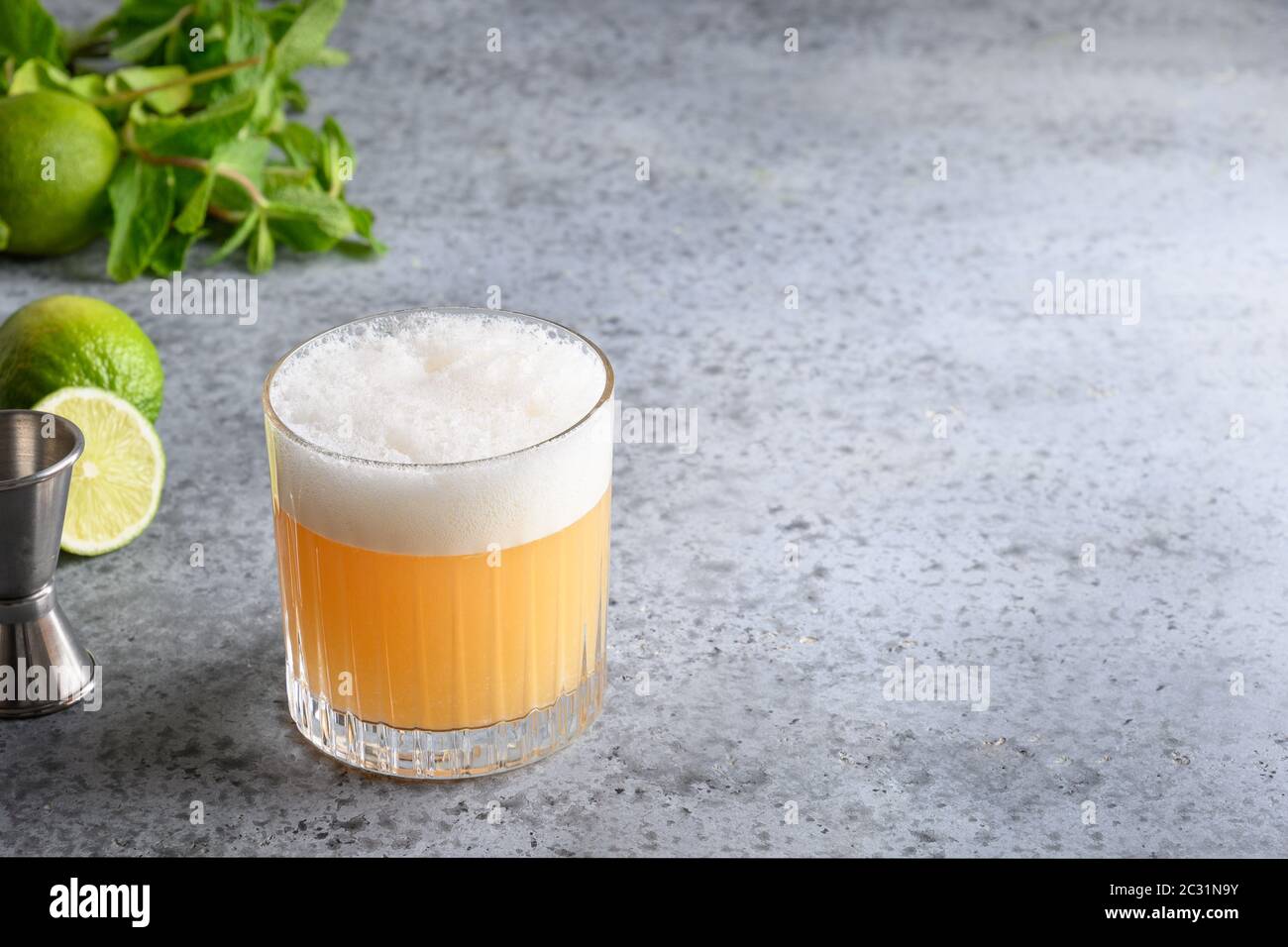 Cocktail Pisco Sour. Wiskey con lime, albume d'uovo, miele su grigio. Primo piano. Foto Stock