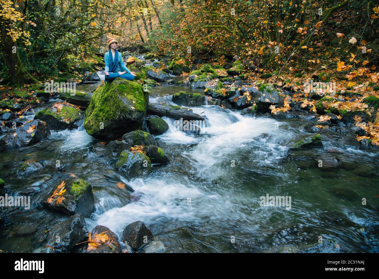 Vista della donna in posa yoga Rocky Brook Falls, Brinnon, Washington, Stati Uniti Foto Stock