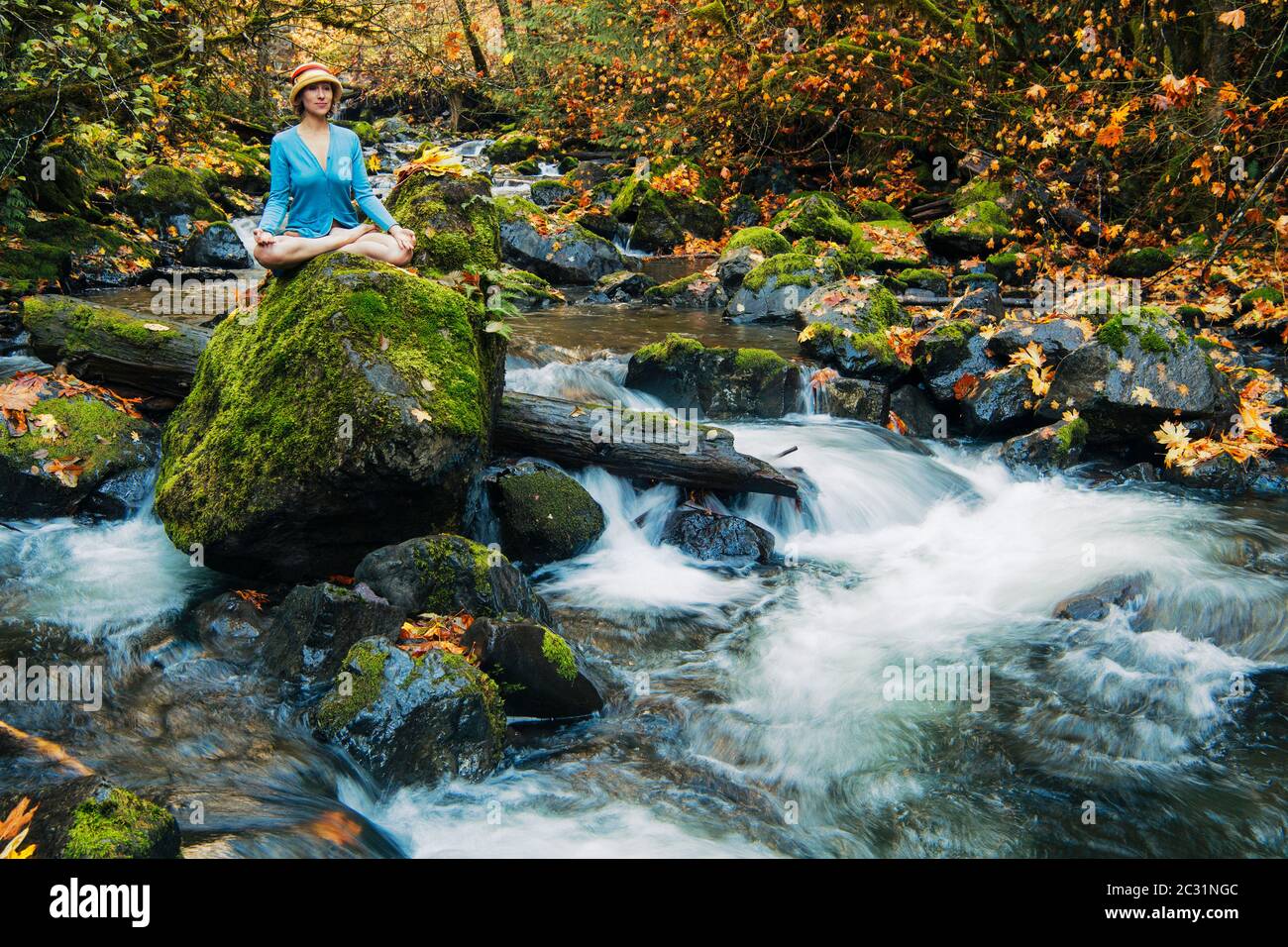 Vista della donna in posa yoga Rocky Brook Falls, Brinnon, Washington, Stati Uniti Foto Stock