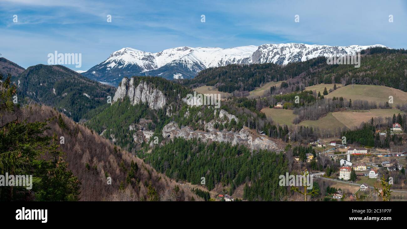 Viadotto e tunnel sulla Semmering Railway con la catena montuosa del Rax sullo sfondo. La ferrovia di Semmering è la più antica ferrovia montana dell'EUR Foto Stock