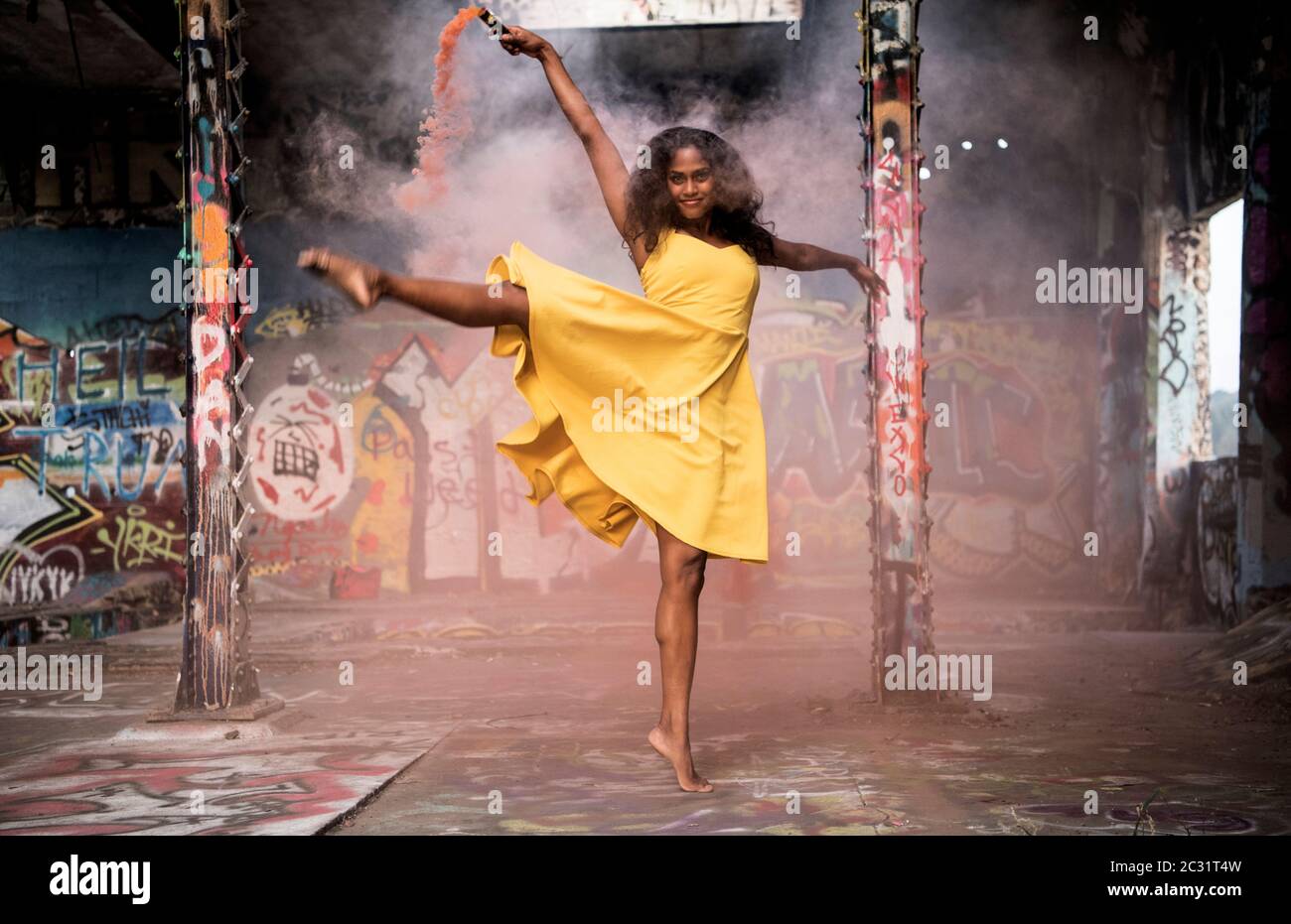 Donna danzante in abito giallo Foto Stock