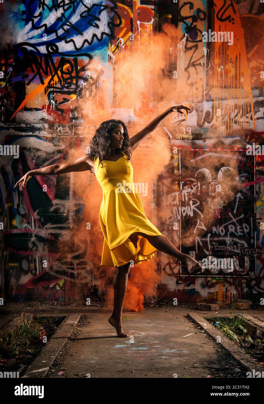 Donna danzante in abito giallo Foto Stock