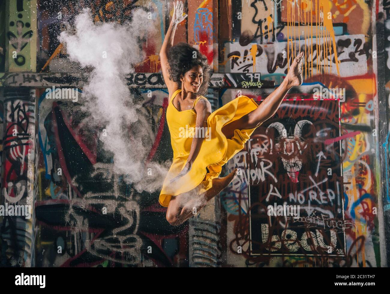 Vista su danzatori moderni e graffiti sullo sfondo Foto Stock
