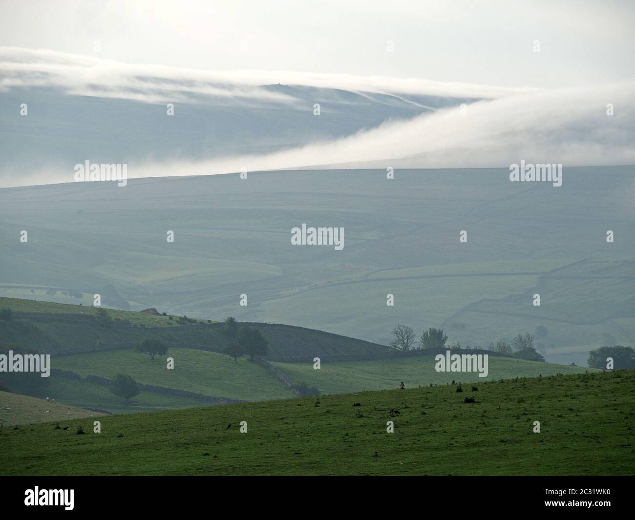 Paesaggio nebboso della mattina presto con inversione di nuvola nelle colline in fase di receding dei Pennines del Nord in Cumbria, Inghilterra, Regno Unito Foto Stock