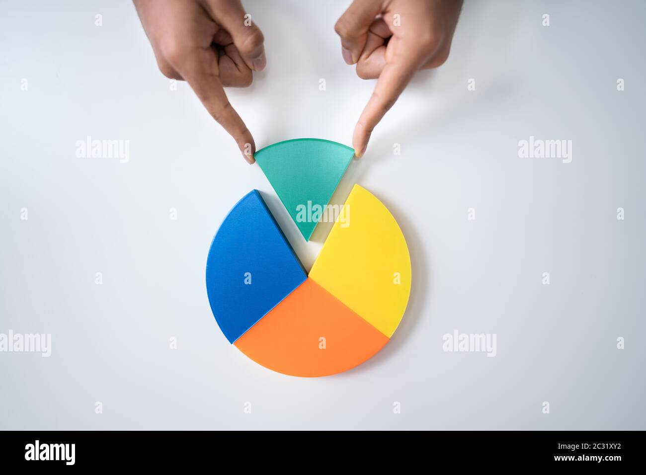 Angolo di Alta Vista di commercianti la mano collocando un ultimo pezzo nel grafico a torta Foto Stock