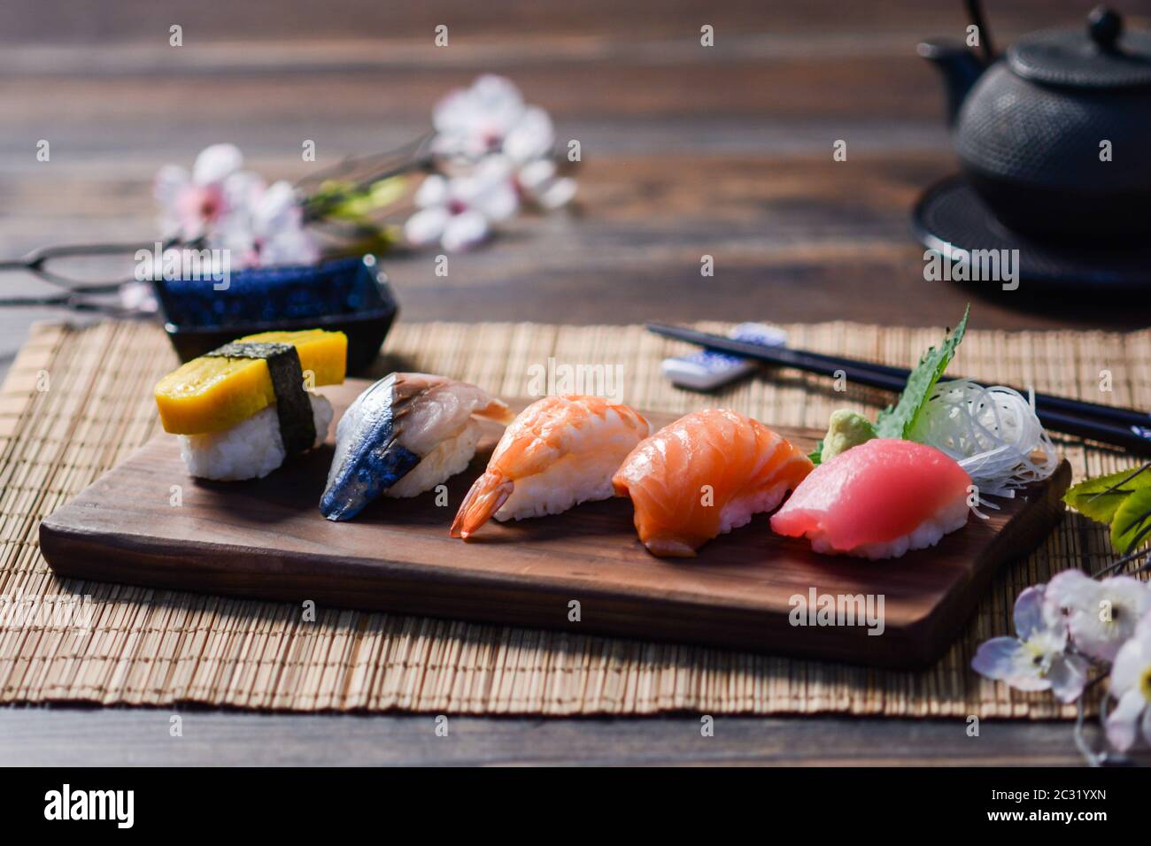 Mescolare il sushi su un piatto di legno, tonno, salmone, spigola, uovo dolce, sushi di gamberi, cibo giapponese Foto Stock