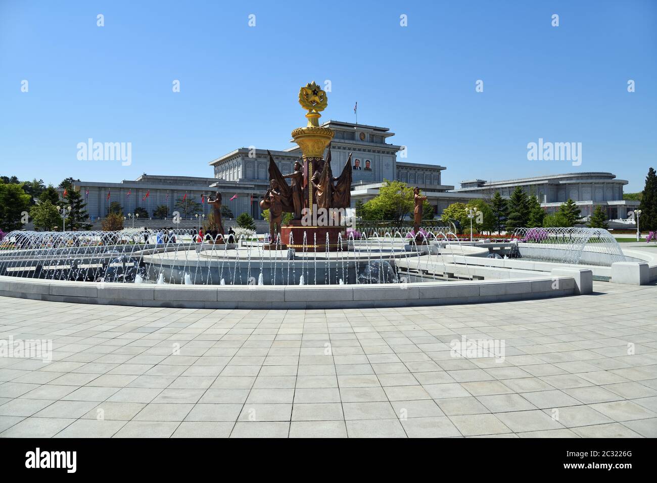 Pyongyang, Corea del Nord - 2 maggio 2019: Fontana con sculture di cantinelle con bandiere e musicisti nel parco del Kumsuyan Memorial Palace del Sun. Ma Foto Stock