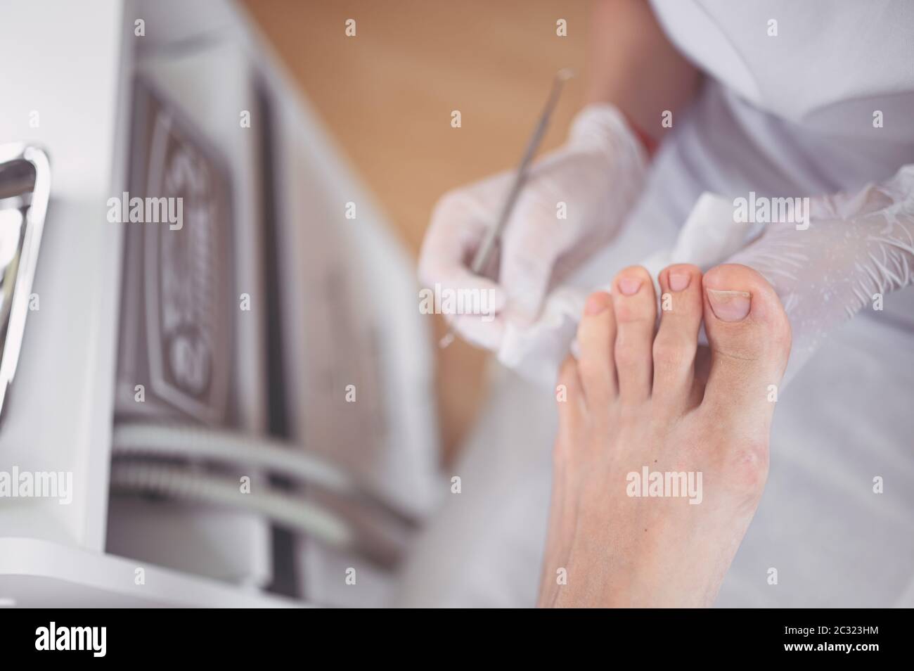 Procedura medica professionale di pedicure primo piano utilizzando doppio strumento unghia. Paziente in visita chiropodista podiatrist. Trattamento dei piedi nel salone SPA Foto Stock