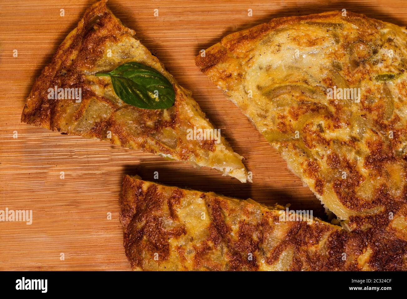 Una fetta di omelette spagnola in un tavolo di legno. Piatto tradizionale spagnolo Foto Stock