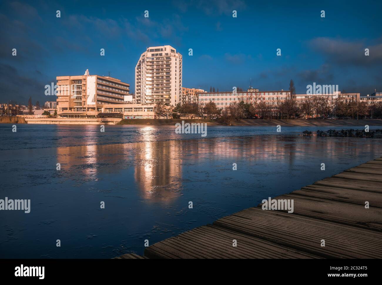 Edifici per uffici con riflessioni in semi Forzen Strkovec lago a Bratislava, in Slovacchia Foto Stock