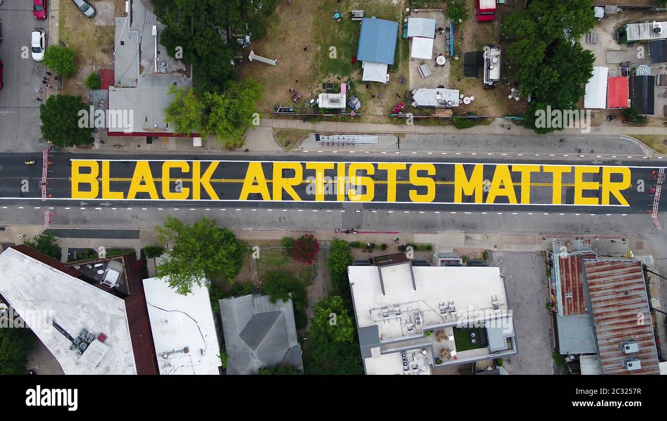 Austin, TX USA 18 giugno 2020: Le lettere gialle della città di Austin che scrivono 'Black Artists Matter' sono dipinte nel quartiere storicamente nero di East 11th Street ad Austin dopo che una coalizione di artisti e attivisti ha terminato il murale. Il dipinto è venuto due giorni dopo che lo stesso gruppo ha dipinto 'Black Austin Matters' sulla Main Street di Austin, Congress Avenue.Credit: ATXN via Bob Daemmrich/Alamy Live News Foto Stock