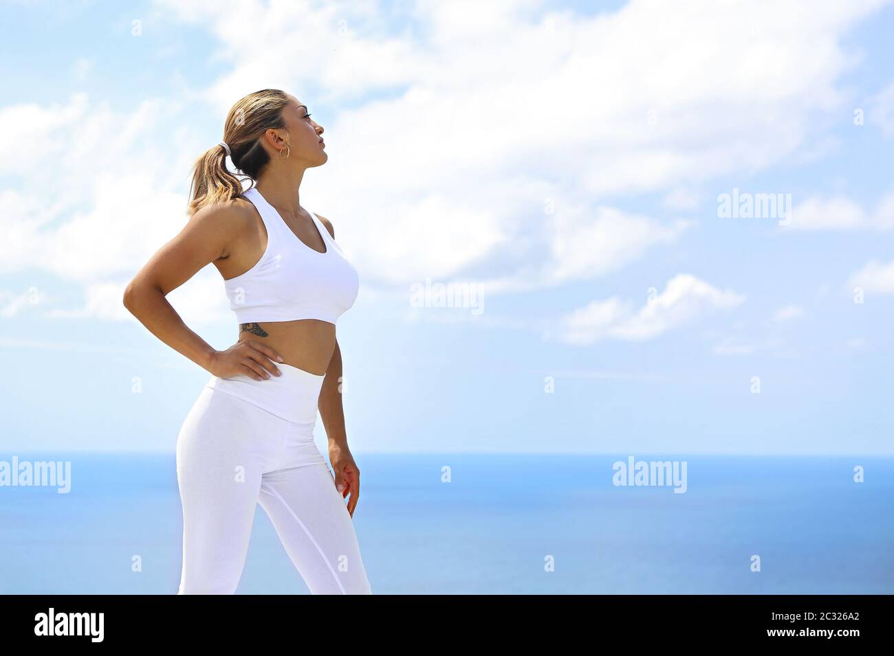 Bella donna che fa esercizi di stretching in spiaggia Foto Stock