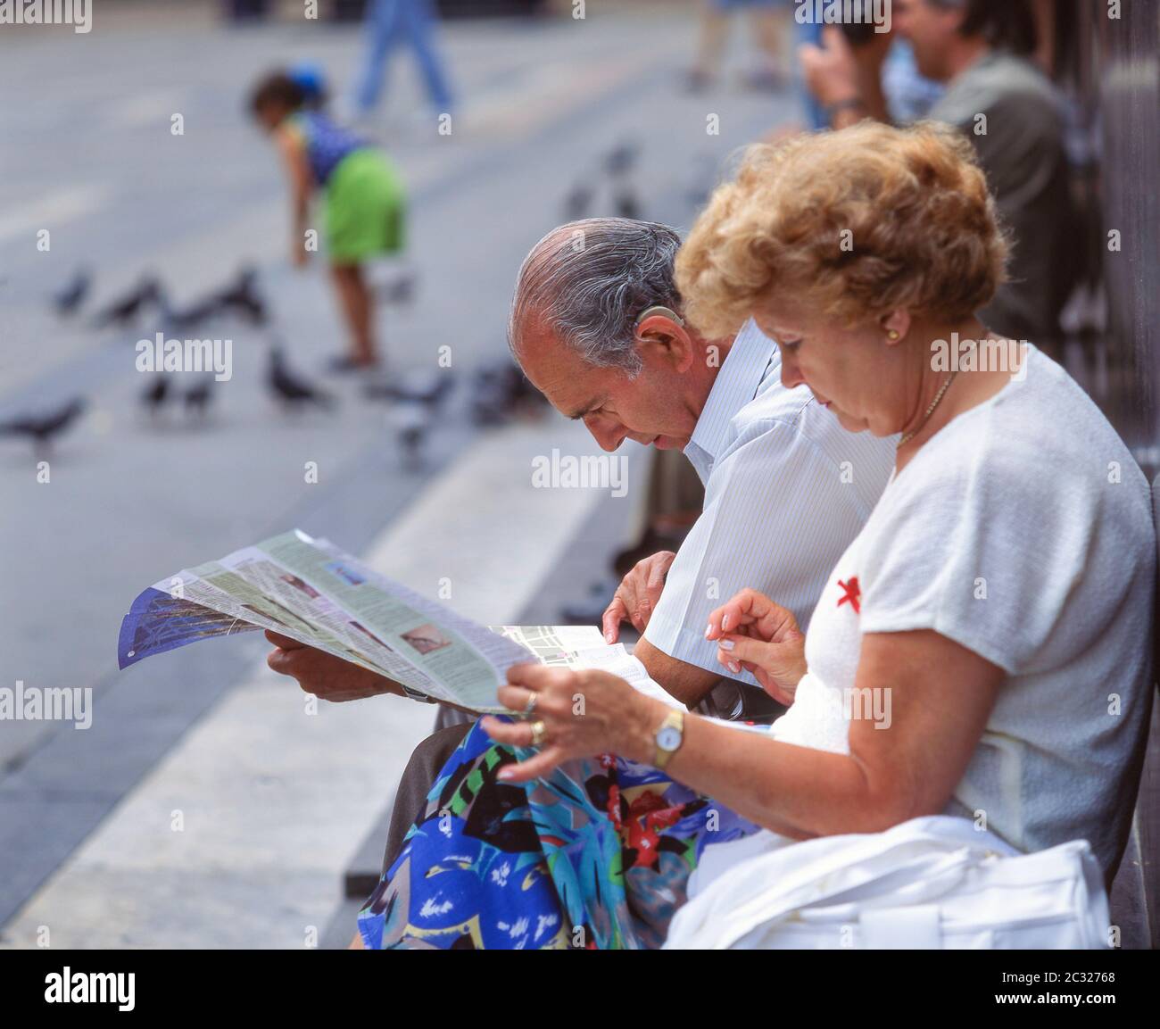 Coppie anziane che guardano alla mappa della città, Piazza del Duomo, Milano (Milano), Regione Lombardia, Italia Foto Stock