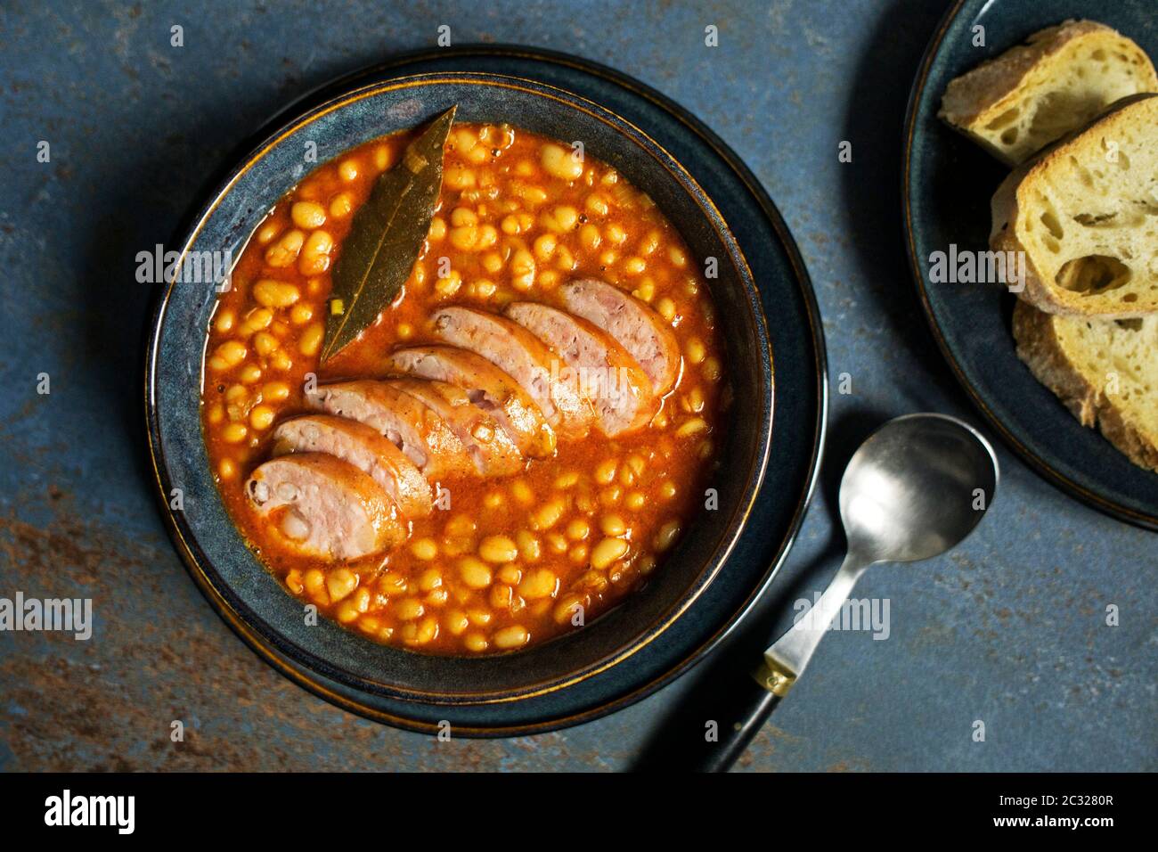 Stufato di fagioli al forno con salsa di pomodoro e salsiccia alle erbe Foto Stock