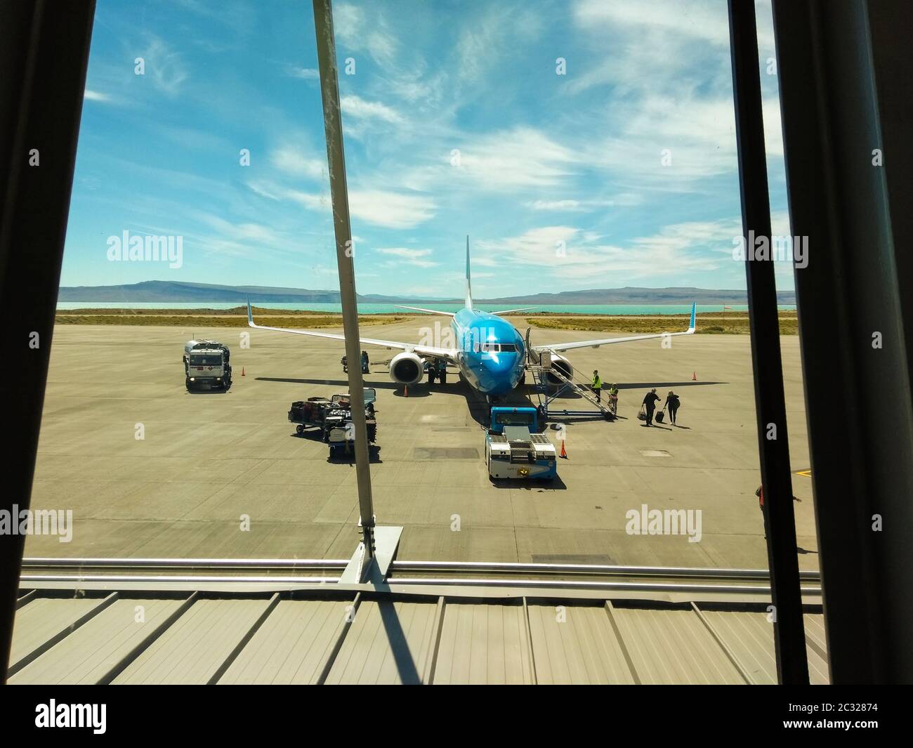 Calafate, Argentina. Gennaio 16 2019. Finestra in aeroporto con un aereo visibile e persone che entrano in aereo. Concetto di viaggio, vacanze e vacanza Foto Stock