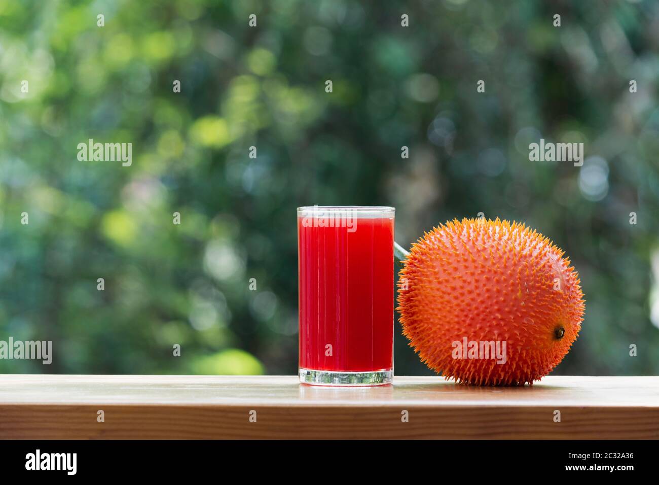 Baby Jackfruit, frutta GAC con succo di jackfruit su sfondo sfocato. Bevanda e concetto sano. Foto Stock