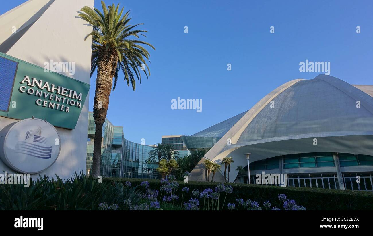 Arena presso l'Anaheim Convention Center, con cartello di benvenuto e palme contro il cielo blu Foto Stock