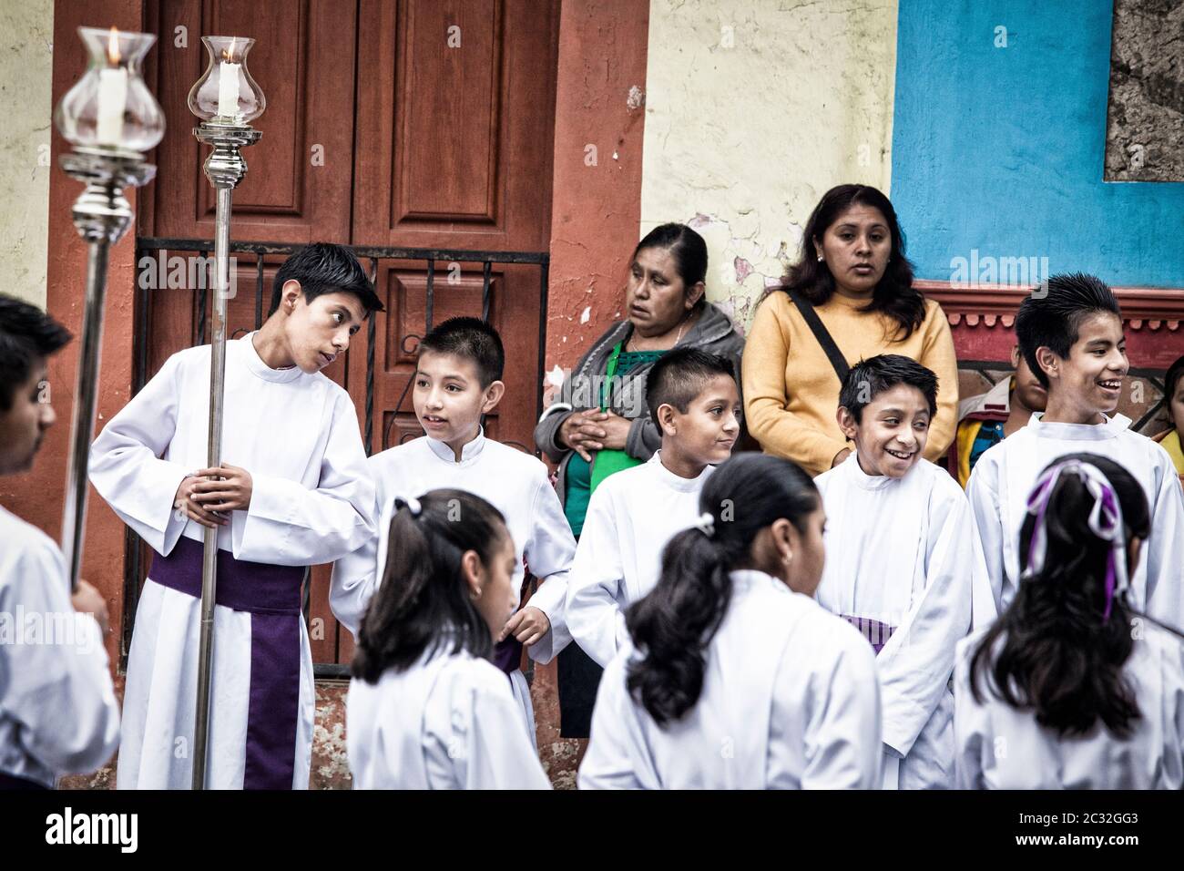 Una processione pasquale a Xico, Veracruz, Messico, ragazzi che ridono mentre altri spettatori sembrano annoiarsi. Foto Stock