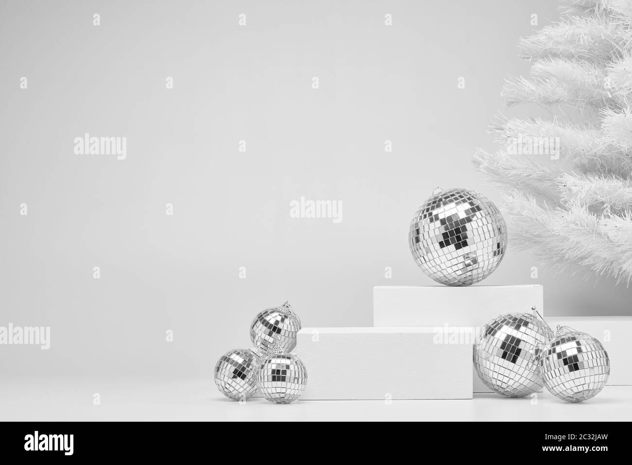 Composizione festosa con figure geometriche bianche, abeti natalizi e palline miroride isolate su sfondo bianco con spazio copia. Per la progettazione di annunci Foto Stock