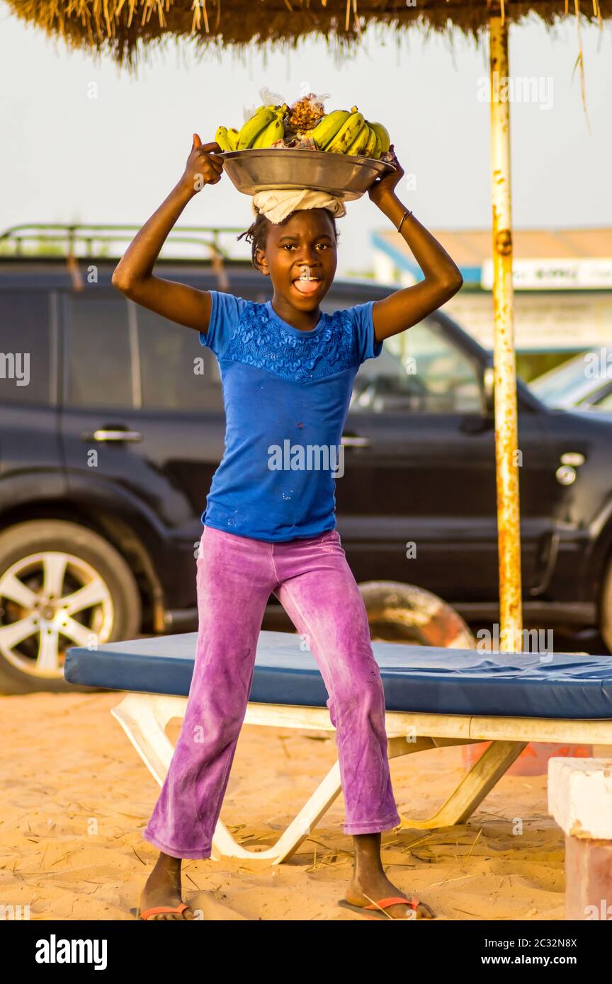 Donna che vende frutta in un cestino sulla spiaggia di Bijilo in Gambia Foto Stock