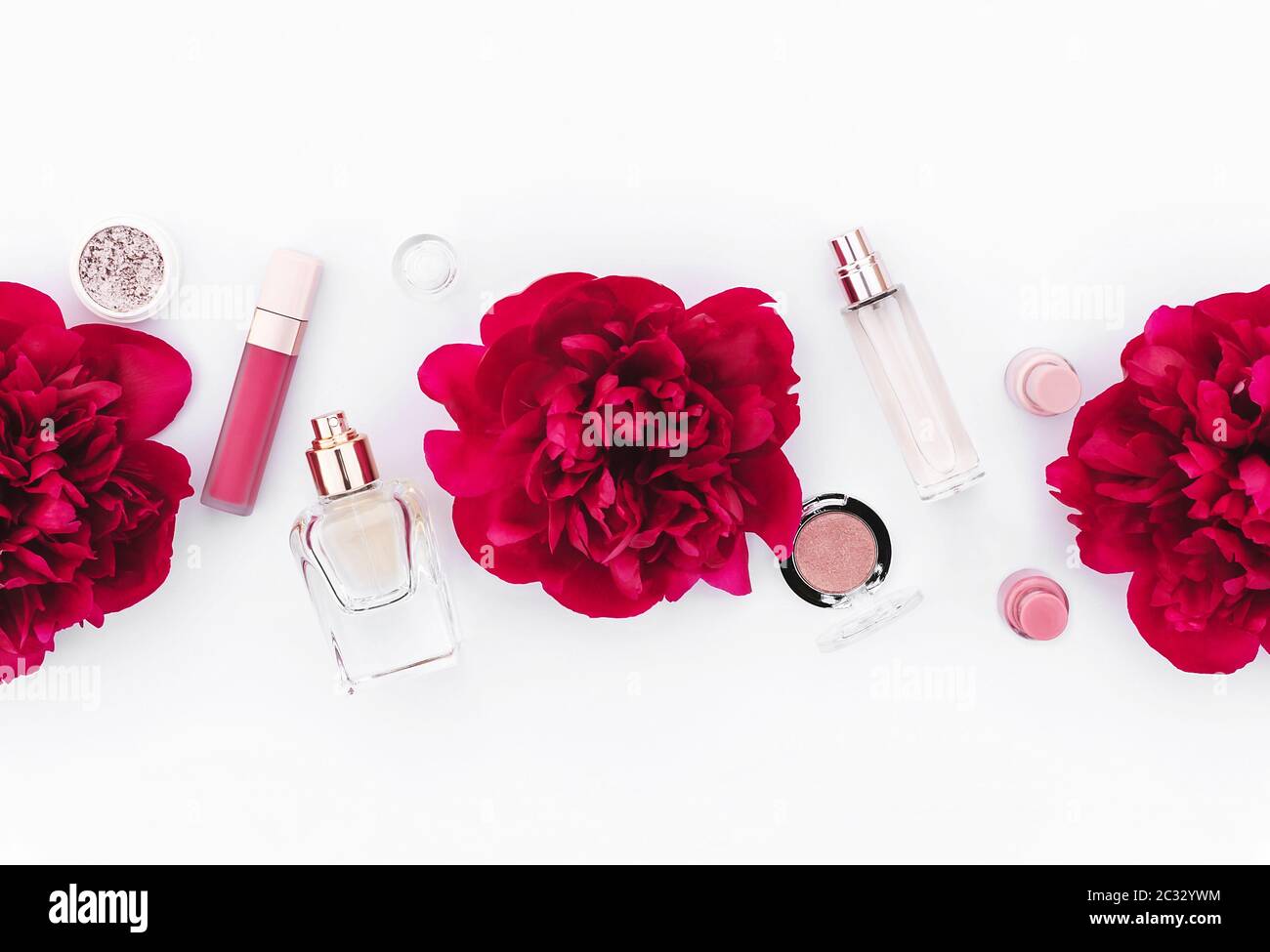 Modello di design alla moda con layout di cosmetici rosa decorato con peonie rosse di vino su sfondo bianco. Stile di posa piatto. Spazio di copia. Mockup per il vostro des Foto Stock