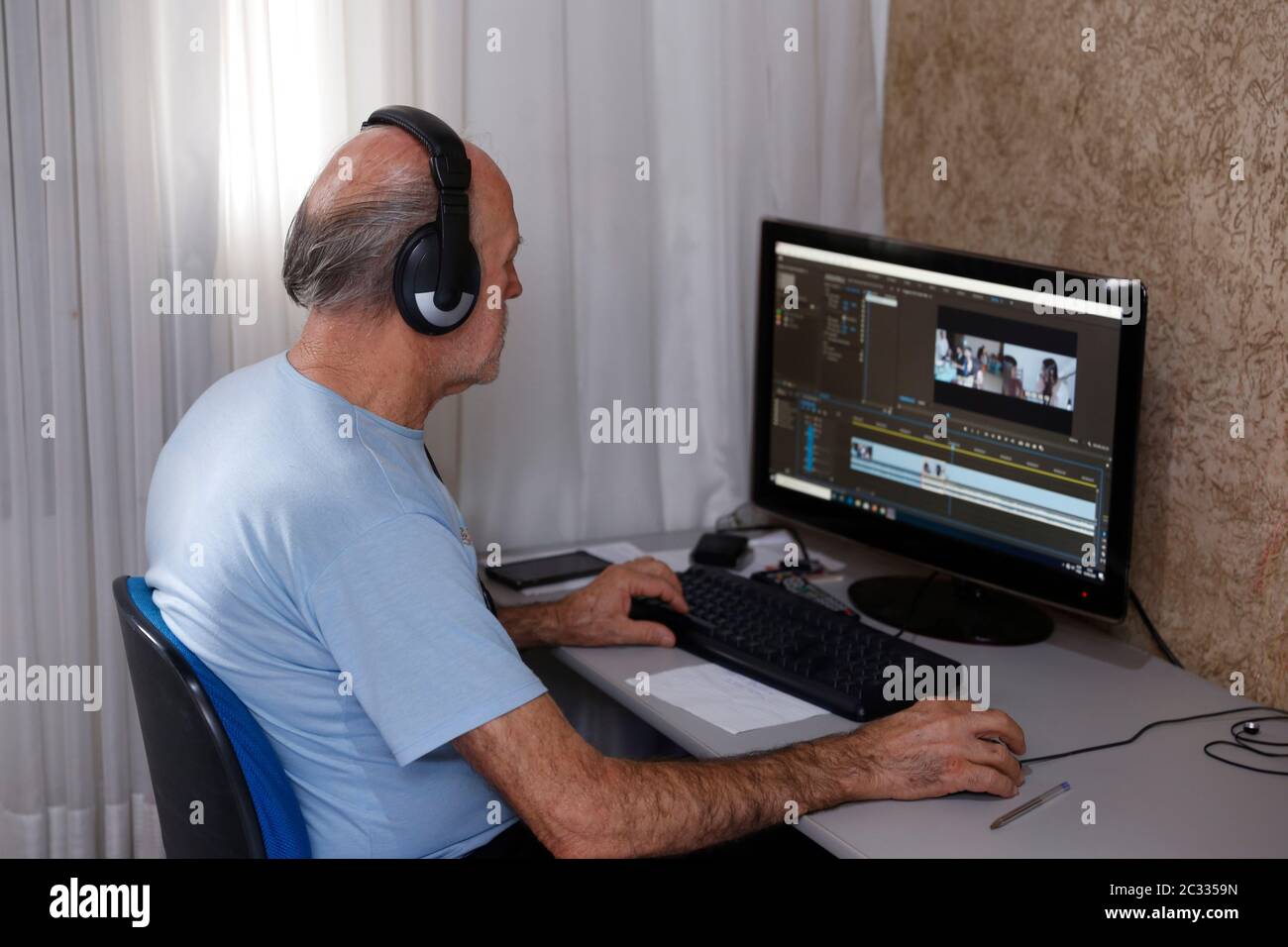 uomo adulto anziano che lavora da casa utilizzando il computer, sistema di ufficio domestico Foto Stock