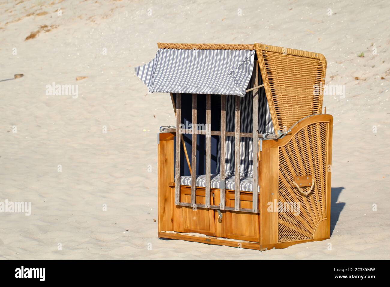 Una sedia da spiaggia chiusa si trova solo sulla spiaggia del Mar Baltico Foto Stock